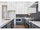 Modern kitchen with a gray island, white cabinets, and sleek stainless steel microwave and oven at 9688 Winterset Cir, Littleton, CO 80125