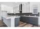 Spacious kitchen with a gray island, white cabinets, and sleek backsplash with modern appliances at 9688 Winterset Cir, Littleton, CO 80125