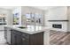 Modern kitchen island and stone fireplace with bright natural light throughout the open space at 9688 Winterset Cir, Littleton, CO 80125
