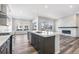 Open concept kitchen with modern appliances, fireplace, island, and breakfast bar at 9688 Winterset Cir, Littleton, CO 80125