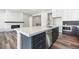 Modern kitchen with a gray island and a fireplace, plus stainless steel appliances at 9688 Winterset Cir, Littleton, CO 80125