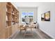Bright home office with a large window, custom shelving and modern decor at 9688 Winterset Cir, Littleton, CO 80125