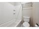 Well-lit bathroom featuring tub with tile surround and a modern toilet at 7995 E Mississippi Ave # 24, Denver, CO 80247