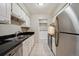 Functional kitchen with white cabinetry, stainless steel appliances, and black countertops at 7995 E Mississippi Ave # 24, Denver, CO 80247