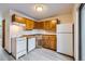 Galley kitchen with wood cabinets and white appliances at 61 S Sable Blvd # C14, Aurora, CO 80012