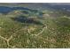 A breathtaking high-angle aerial view of a community nestled among mountains and lush greenery at 30866 Kings Valley Way, Conifer, CO 80433