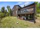 Landscaped backyard with hot tub, and a cozy outdoor seating area with mature trees at 30866 Kings Valley Way, Conifer, CO 80433