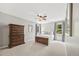 Bright bedroom features a ceiling fan, dresser, and windows with wooded views at 30866 Kings Valley Way, Conifer, CO 80433