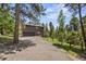 Two-story home with a large driveway and lots of trees in the background at 30866 Kings Valley Way, Conifer, CO 80433