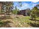 Exterior view showcasing the home's lush surroundings and well-maintained lawn at 30866 Kings Valley Way, Conifer, CO 80433