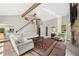 Bright living room features a stone fireplace, vaulted ceiling, and an adjacent staircase at 30866 Kings Valley Way, Conifer, CO 80433