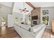 Comfortable living room with vaulted ceiling, wood beam, and large stone fireplace at 30866 Kings Valley Way, Conifer, CO 80433