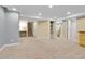 Spacious finished basement with neutral carpet, stairs, and a bathroom area at 12718 W 84Th Dr, Arvada, CO 80005