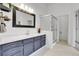 Bright bathroom featuring a dark vanity with gold hardware and a glass-enclosed shower at 12718 W 84Th Dr, Arvada, CO 80005