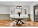 Cozy dining area with a rustic table, modern lighting, and a view of the lush greenery outside at 12718 W 84Th Dr, Arvada, CO 80005