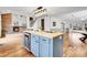 Kitchen island boasts wood countertop, blue cabinets, beverage fridge, and pendant lighting at 12718 W 84Th Dr, Arvada, CO 80005