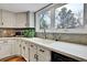 Bright kitchen features a white sink, quartz counters, patterned backsplash, and stainless steel appliances at 12718 W 84Th Dr, Arvada, CO 80005