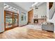 Open living room boasts a brick fireplace, vaulted ceiling, wood floors, and glass doors at 12718 W 84Th Dr, Arvada, CO 80005
