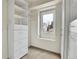 Bright walk-in closet with custom shelving and cabinets, plus a window for natural light at 12718 W 84Th Dr, Arvada, CO 80005