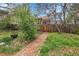 Brick path leading through a yard with green grass and trees at 12718 W 84Th Dr, Arvada, CO 80005