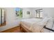 Inviting bedroom featuring hardwood floors, natural light from two windows, and clean, white linens at 7910 Hooker St, Westminster, CO 80030