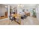 Open dining room featuring a modern light fixture and view into the living room with a stone fireplace at 7910 Hooker St, Westminster, CO 80030
