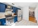Functional kitchen featuring updated stainless steel appliances and beautiful blue cabinets at 7910 Hooker St, Westminster, CO 80030