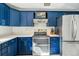 Modern kitchen featuring stainless steel appliances, white countertops, and stylish blue cabinets at 7910 Hooker St, Westminster, CO 80030