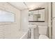 Classic bathroom featuring subway tile, a pedestal sink, and a refinished tub at 1340 Iola St, Aurora, CO 80010