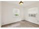 Clean bedroom with neutral carpet, two windows for natural light, and air conditioner at 1340 Iola St, Aurora, CO 80010