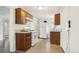 Functional kitchen featuring wooden cabinets, white appliances, and light granite countertops at 1340 Iola St, Aurora, CO 80010