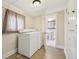 Practical laundry area with side-by-side machines, tile flooring, and storage cabinet at 1340 Iola St, Aurora, CO 80010