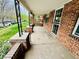 Covered porch with brick columns, concrete floor, and view of the front yard at 767 S York St, Denver, CO 80209