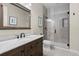 Modern bathroom featuring a marble countertop, dark wood vanity, and glass-enclosed shower at 10597 Soulmark Way, Highlands Ranch, CO 80126