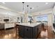 Open kitchen layout with island seating, pendant lights, and hardwood flooring overlooking the living area at 10597 Soulmark Way, Highlands Ranch, CO 80126