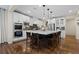 Modern kitchen with stainless appliances, center island with seating, and pendant lighting at 10597 Soulmark Way, Highlands Ranch, CO 80126
