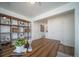 Well-lit office space showcasing a wooden desk and shelving unit for storage and decor at 13545 E 103Rd Ave, Commerce City, CO 80022