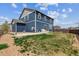 Large backyard with a well-manicured lawn, concrete patio, and a blue-sided house with a shingled roof at 7498 E 157Th Pl, Thornton, CO 80602