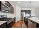 Modern kitchen featuring stainless steel appliances, dark cabinets, and quartz countertops at 7498 E 157Th Pl, Thornton, CO 80602