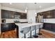 Modern kitchen with stainless steel appliances, dark cabinetry, and a center island with seating at 7498 E 157Th Pl, Thornton, CO 80602