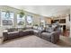 Open-concept living room featuring large windows and comfortable seating at 7498 E 157Th Pl, Thornton, CO 80602