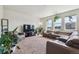 Spacious living room with cozy seating, plush carpet, and ample natural light at 7498 E 157Th Pl, Thornton, CO 80602