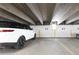 A white SUV is parked in the indoor parking garage with a cement ceiling and white walls at 2 Adams St # 809, Denver, CO 80206