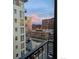 Condo view of a nearby building and parking structure during a vivid pink sunrise at 2 Adams St # 809, Denver, CO 80206