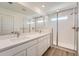 Bathroom with double sinks, white cabinets and glass enclosed shower showcasing clean lines at 1280 S Algonquian St, Aurora, CO 80018