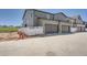 Modern townhouse featuring a two-car garage, gray siding, and white privacy fence at 1280 S Algonquian St, Aurora, CO 80018