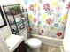 Compact bathroom featuring a vanity, toilet, and shower with a cheerful floral curtain at 1641 S Zenobia St, Denver, CO 80219