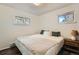 Bright bedroom with two windows and a wooden nightstand next to the bed at 28669 Mountain View Rd, Conifer, CO 80433