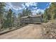 The exterior of this mountain house features a charming deck and a natural landscape for serene outdoor living at 28669 Mountain View Rd, Conifer, CO 80433