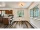 An eat-in kitchen area with wooden floors, a window with treed views and bar stool seating at 28669 Mountain View Rd, Conifer, CO 80433